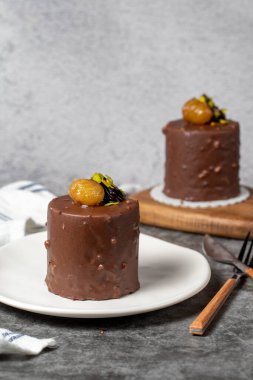 Koyu arkaplanda çikolata ve kestane rengi kek. Kremalı lezzetli pasta. Stüdyo çekimi. Fırın ürünleri. Kapat.