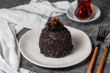 Koyu arkaplanda çikolata ve fıstıklı kek. Kremalı lezzetli pasta. Stüdyo çekimi. Fırın ürünleri. Kapat.