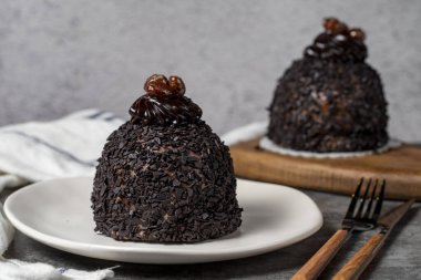Koyu arkaplanda çikolata ve fıstıklı kek. Kremalı lezzetli pasta. Stüdyo çekimi. Fırın ürünleri. Kapat.