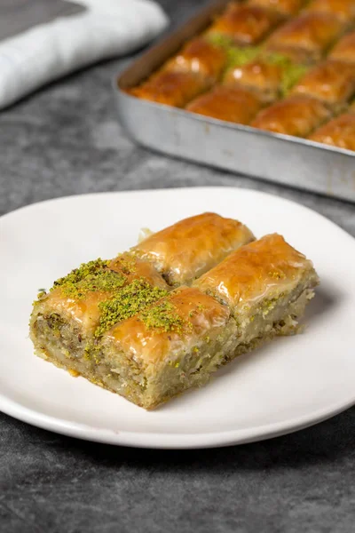 Baklava with pistachio on a dark background. Traditional Turkish baklava in a plate. Studio shoot. close up