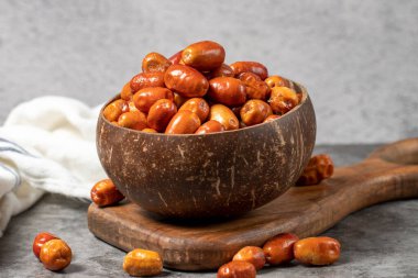 Koyu arkaplanda taze taze gümüş meyveler. Hindistan cevizi kasesinde gümüş çilek. Oleaster veya Rus zeytini (Elaeagnus). Kapat.