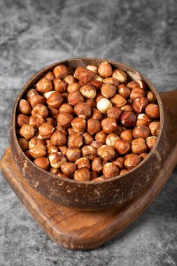 Koyu fındıklı fındıklar. Hindistan cevizi kasesinde fındık. Stüdyo çekimi. Kapat.