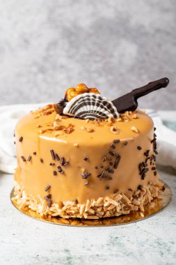 Caramel cake on a gray background. Chocolate and hazelnut birthday or celebration cake. Bakery desserts. vertical view. close up