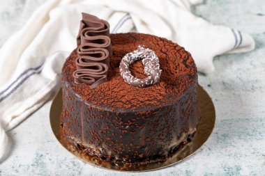 Chocolate cake on a gray background. A birthday or celebration cake filled with strawberries, bananas and chocolate. Bakery desserts. close up