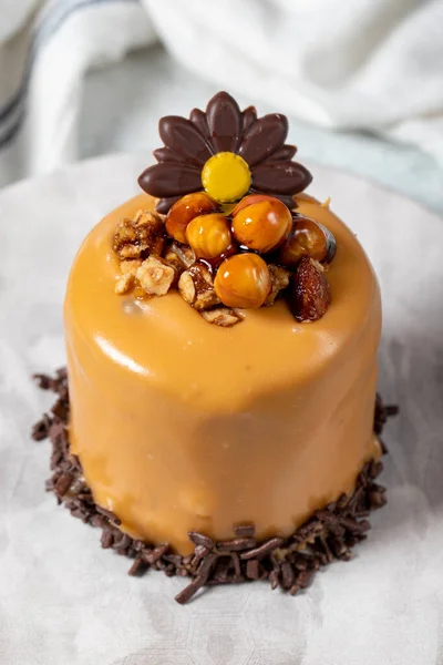 Caramel cake on a gray background. Chocolate and hazelnut cake. Bakery desserts. vertical view. close up