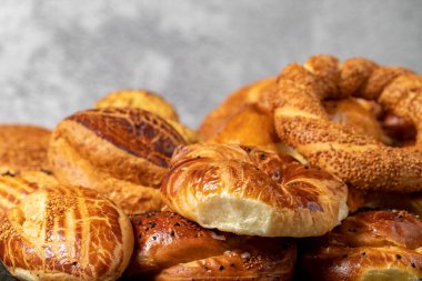 Bagel and pogaca varieties. They eat pastries in piles. Bakery products. Traditional turkish cuisine breakfast culture. Local name simit, pogaca, borek, acma. close up