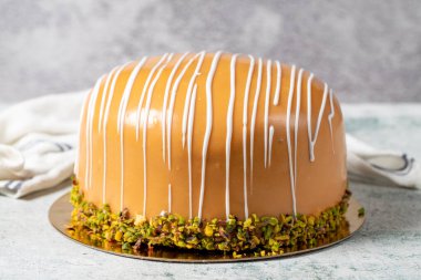 Caramel and pistachio cake. Celebration or birthday cake, covered with caramel on the outside and filled with bananas and strawberries. Special design. close up