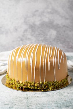 Caramel and pistachio cake. Celebration or birthday cake, covered with caramel on the outside and filled with bananas and strawberries. Special design. close up