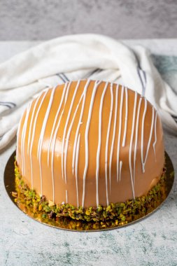 Caramel and pistachio cake. Celebration or birthday cake, covered with caramel on the outside and filled with bananas and strawberries. Special design. close up