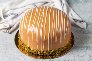 Caramel and pistachio cake. Celebration or birthday cake, covered with caramel on the outside and filled with bananas and strawberries. Special design. close up