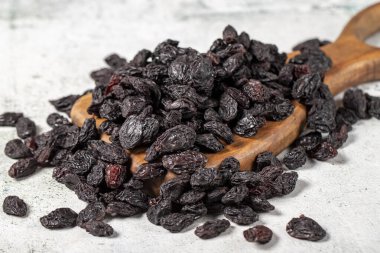 Dried black grapes on stone background. Dried grapes on a wooden serving board. Nuts varieties. Healthy eating. close up