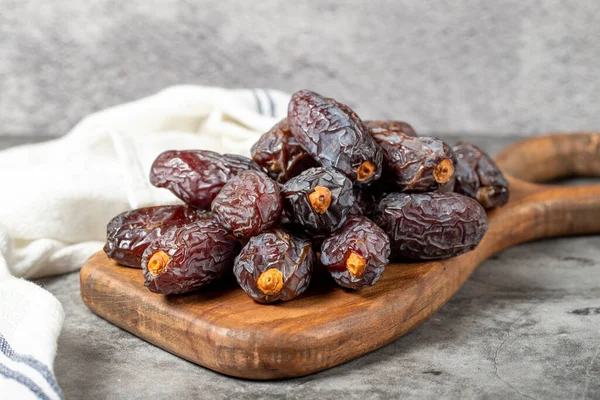 Jerusalem date fruit on stone background. Large date fruit on a wooden serving board. Ramadan food. Healthy eating. close up