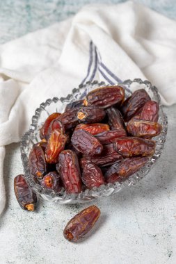 Date fruit on stone background. Organic Medjoul dates in a glass bowl. Ramadan food. close up