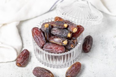 Date fruit on stone background. Organic Medjoul dates in a glass bowl. Ramadan food. close up