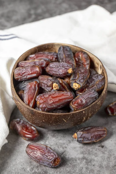Date fruit on a dark background. Organic medjoul dates in bowl. Ramadan food. Close-up