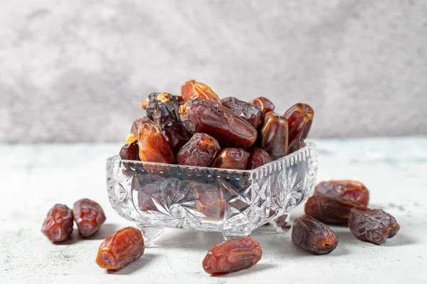 Date fruit on stone background. Organic Medjoul dates in a glass bowl. Ramadan food. close up