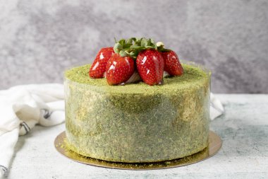 Strawberry cake on a stone background. Fruit and pistachio birthday cake. close up