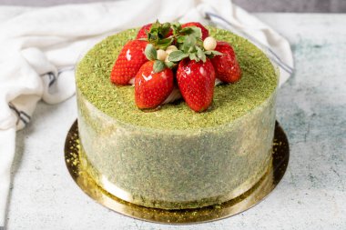 Strawberry cake on a stone background. Fruit and pistachio birthday cake. close up