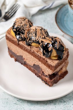 Chocolate and profiteroles cake. Layered cake with chocolate and cream on plate on stone background. close up