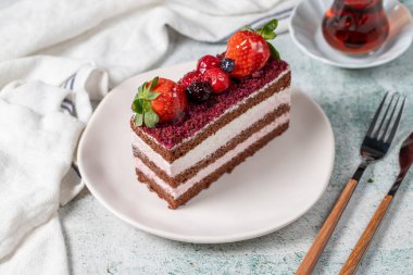 Fruit and whipped cream cake. Layered cake with forest fruit and cream on the plate. close up