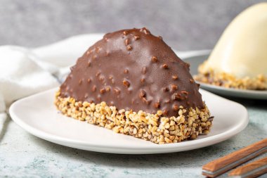 Chocolate Banana Cake. Malaga cake with banana inside, chocolate and hazelnut outside on a stone background. close up