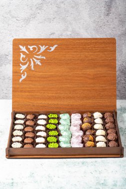 Box with delicious chocolate candies. Truffle chocolate on gray background