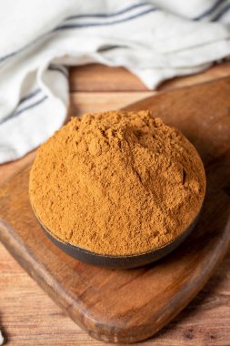 Powdered cinnamon spice. Ground cinnamon in a bowl on a wooden background. Dry spice concept. close up