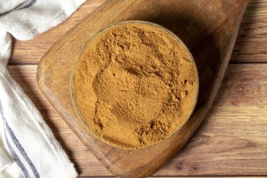 Powdered cinnamon spice. Ground cinnamon in a bowl on a wooden background. Dry spice concept. close up