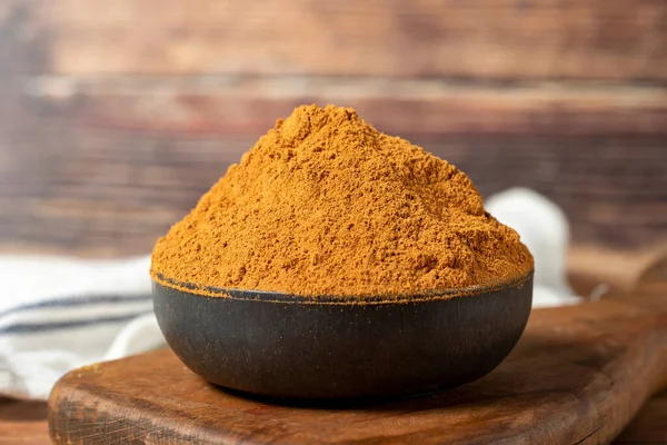 Powdered cinnamon spice. Ground cinnamon in a bowl on a wooden background. Dry spice concept. close up