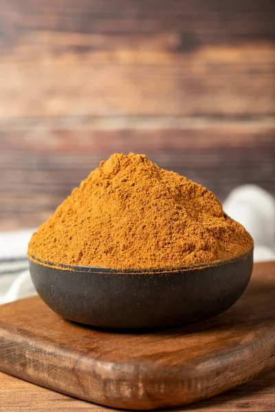 Powdered cinnamon spice. Ground cinnamon in a bowl on a wooden background. Dry spice concept. close up
