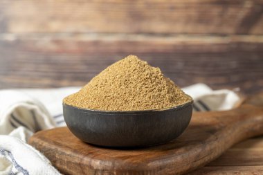 Powdered coriander spice. Coriander powder or dhaniya powder on wooden background. Dry spice concept. close up