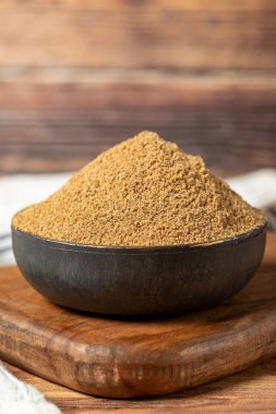 Powdered coriander spice. Coriander powder or dhaniya powder on wooden background. Dry spice concept. close up