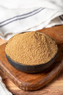 Powdered coriander spice. Coriander powder or dhaniya powder on wooden background. Dry spice concept. close up