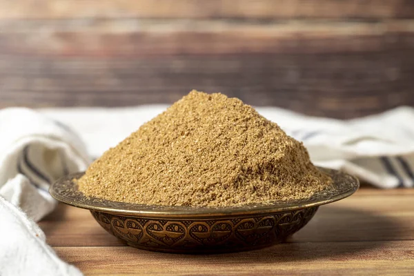 Powdered coriander spice. Coriander powder or dhaniya powder on wooden background. Dry spice concept. close up