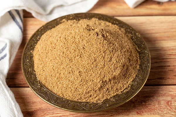 Powdered coriander spice. Coriander powder or dhaniya powder on wooden background. Dry spice concept. close up