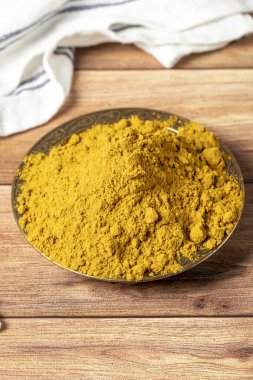 Köri Masala Tozu. Tahta arka planda bir kasede zerdeçal tozu ya da köri tozu. Hint baharatları. Kuru baharat konsepti. Kapat.