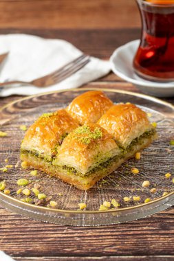 Türk fıstıklı baklava. Türk mutfağı lezzetleri. Ahşap arka planda Baklava. Kapat.