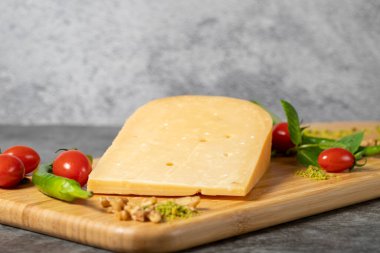 Gouda cheese. Piece of gouda cheese on wooden cutting board. Cheese collection. Ripe hard cheese made from cow's milk in the Netherlands