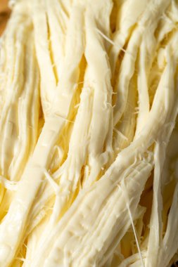 String cheese or Cecil cheese on a wood serving board. Dairy products. Close up
