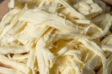 String cheese or Cecil cheese on a wood serving board. Dairy products. Close up