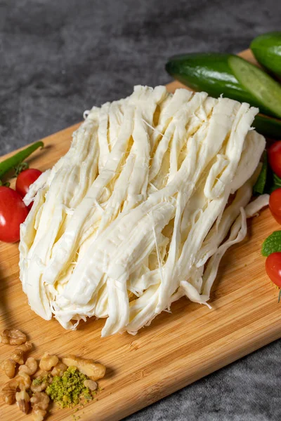 String cheese or Cecil cheese on a wood serving board. Dairy products
