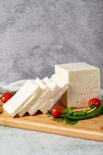 Ripe white cheese. Feta cheese made from cow\'s milk on a wooden serving board. Dairy products. Close up