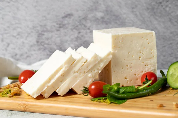 Ripe white cheese. Feta cheese made from cow's milk on a wooden serving board. Dairy products