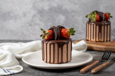 Small cake. Chocolate and strawberry cake in a plate. close up