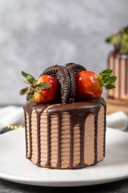 Small cake. Chocolate and strawberry cake in a plate. close up