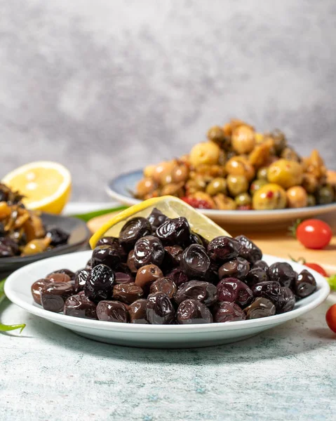 Olive varieties. Assortment of black and green olives on plate on gray background. low angle view