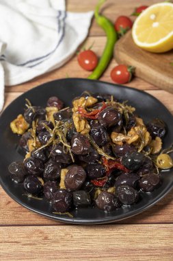 Mixed olives. Dried tomatoes, thyme, rosemary, walnuts and olives on the plate. Mediterranean flavors