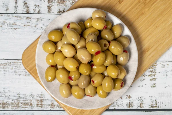 Stuffed olives. Green olives stuffed with dry peppers on a wooden background. Mediterranean flavors. Top view