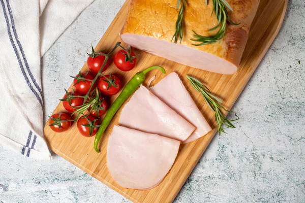 Smoked turkey meat sliced. Smoked turkey/ham fillets on a wood serving board. Deli products. Top view