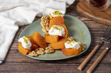 Creamy pumpkin dessert. Turkish Ramadan sweet delicacies. Pumpkin dessert with sorbet on gray background.